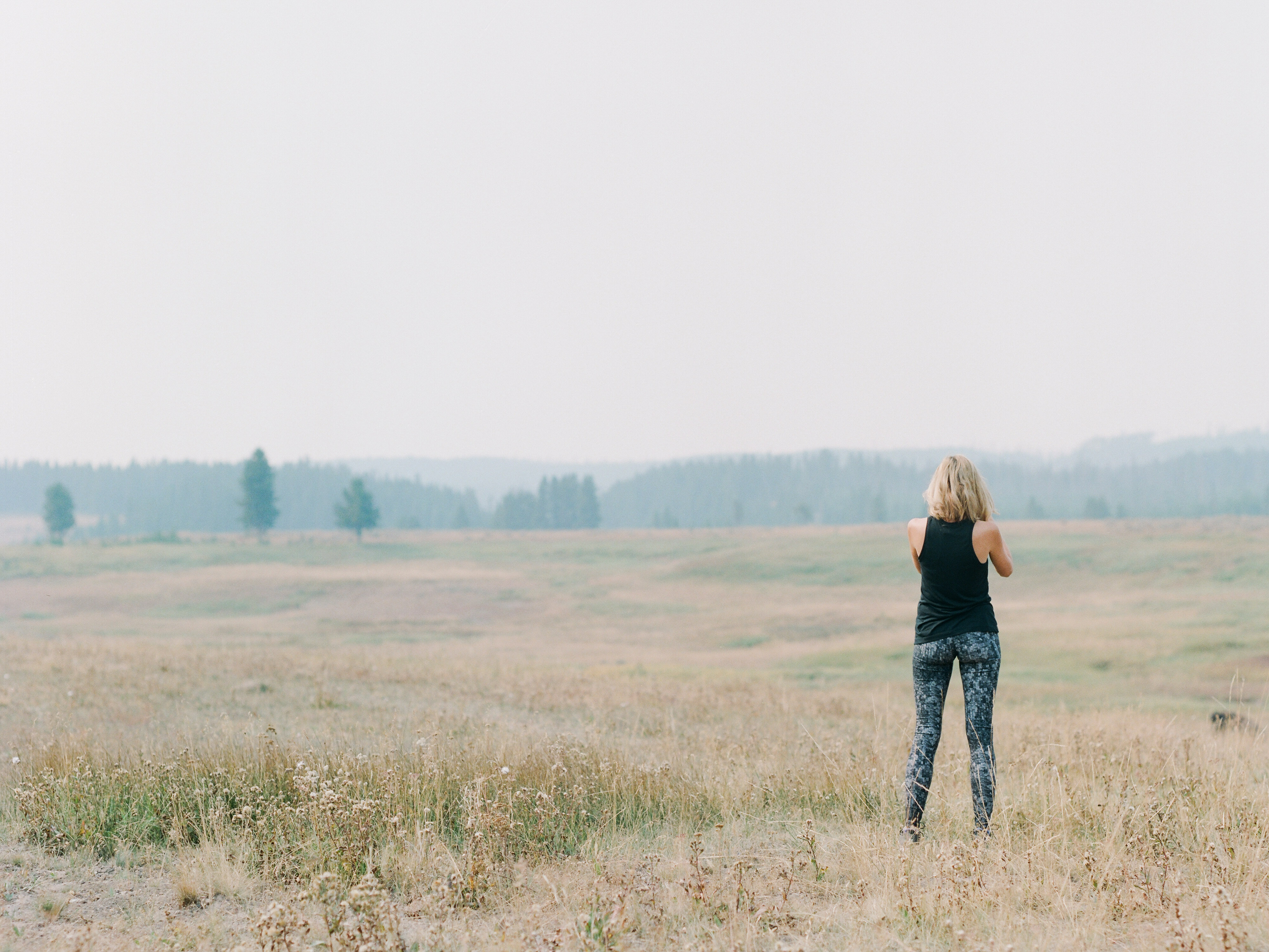 girl standing in open field at Yellowstone National Park