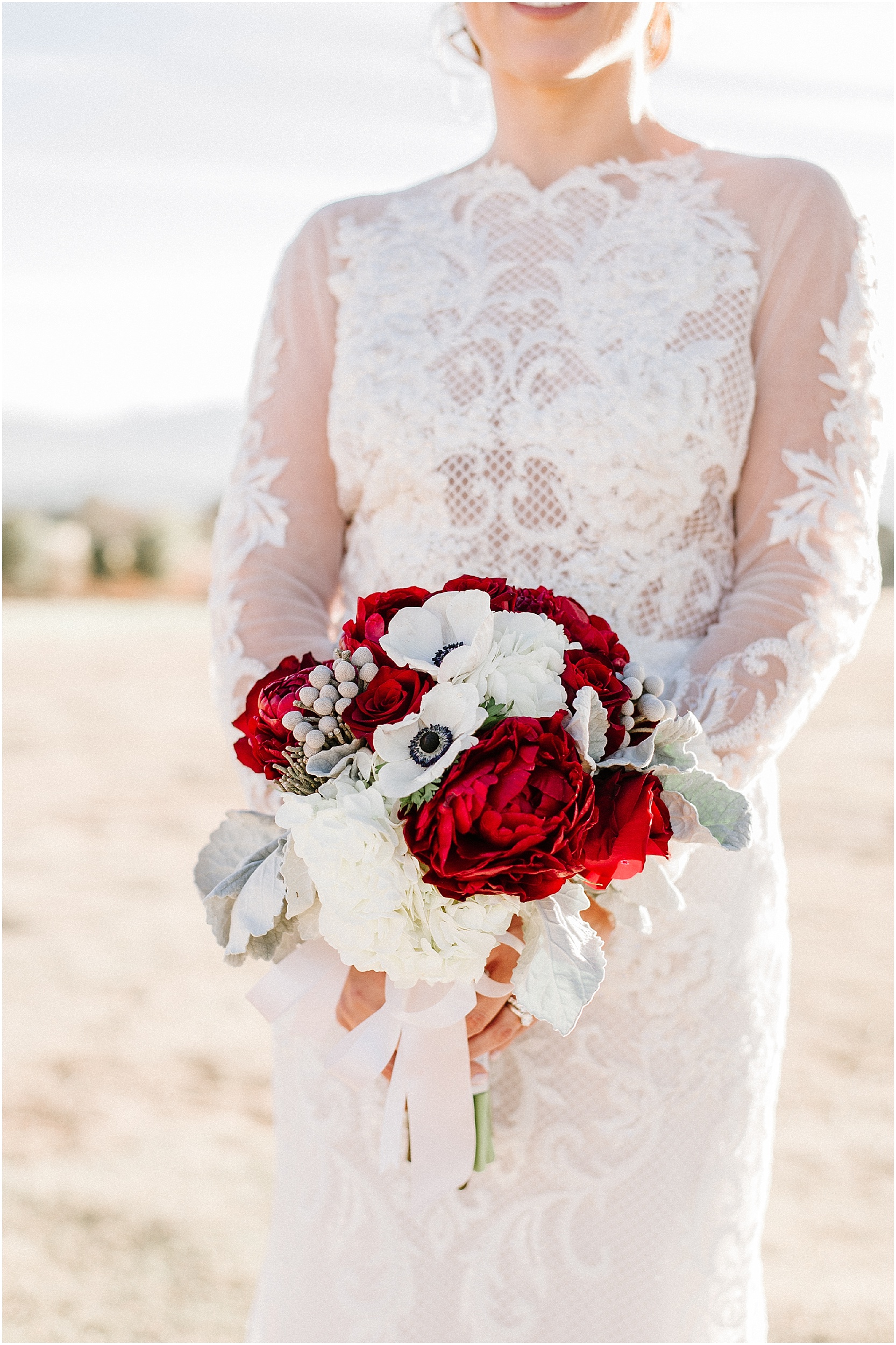 bride holding red and white winter bouquet