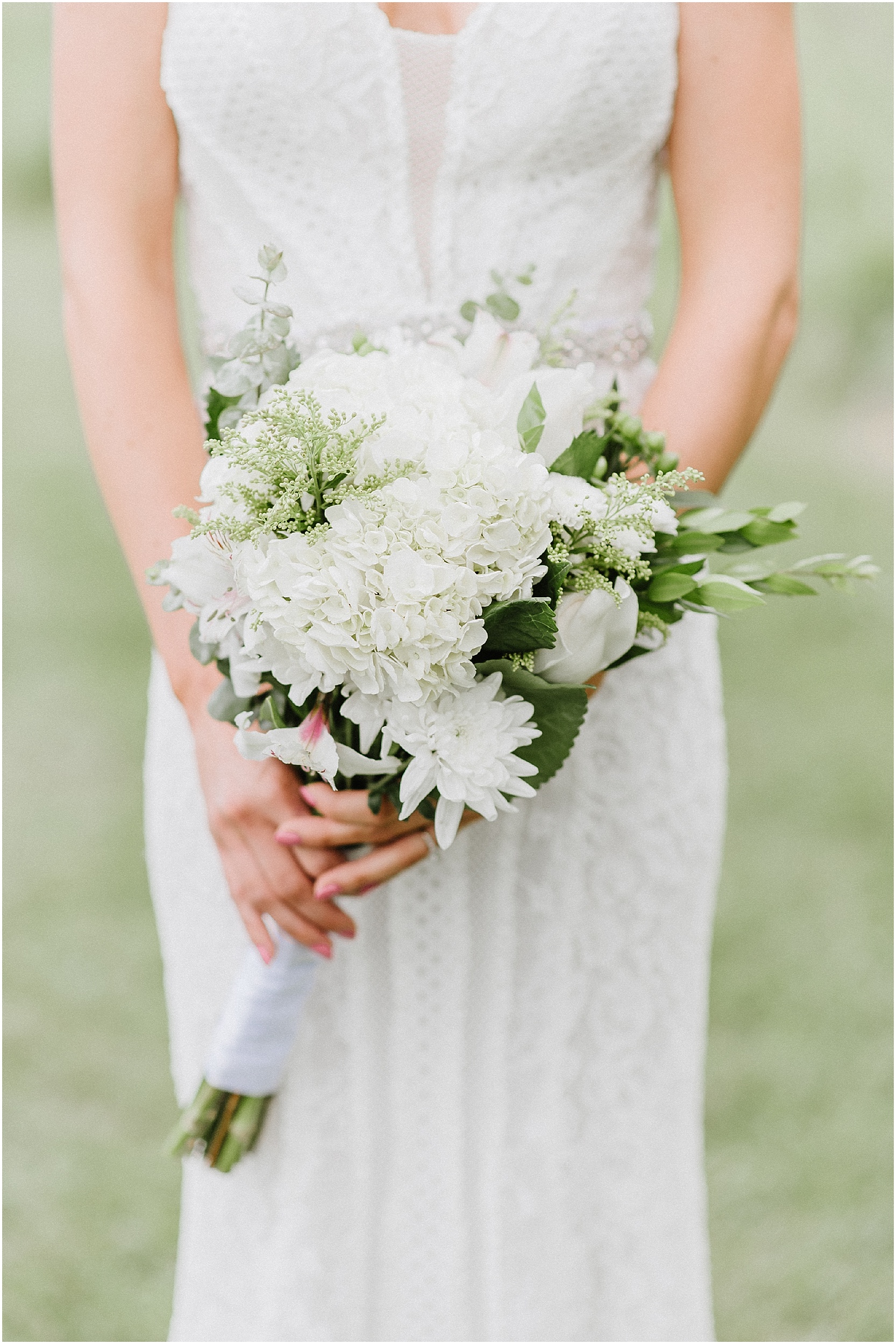 bride holding white and green rustic bouquet