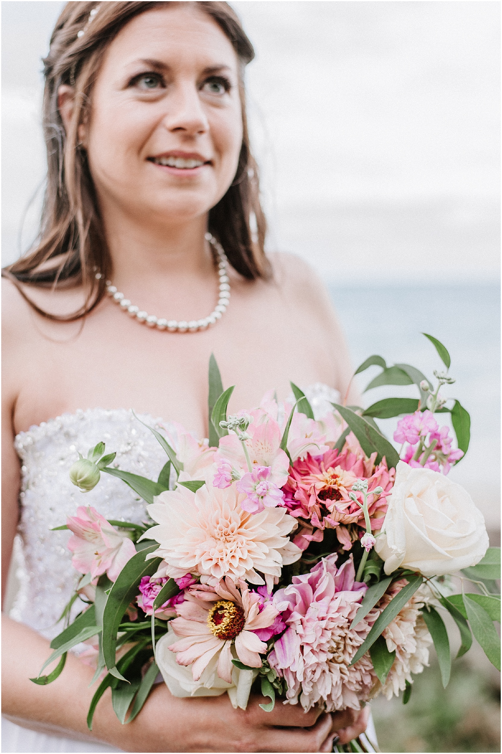 bride holding pink dahlia bouquet