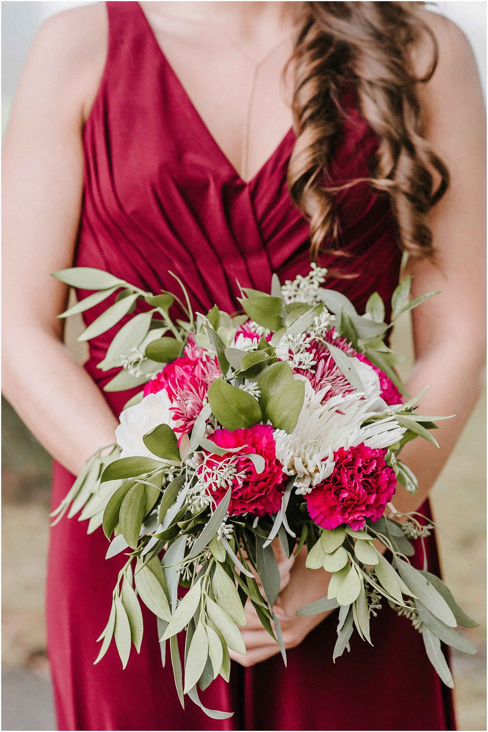 bridesmaid holding rustic burgundy and green fall bouquet