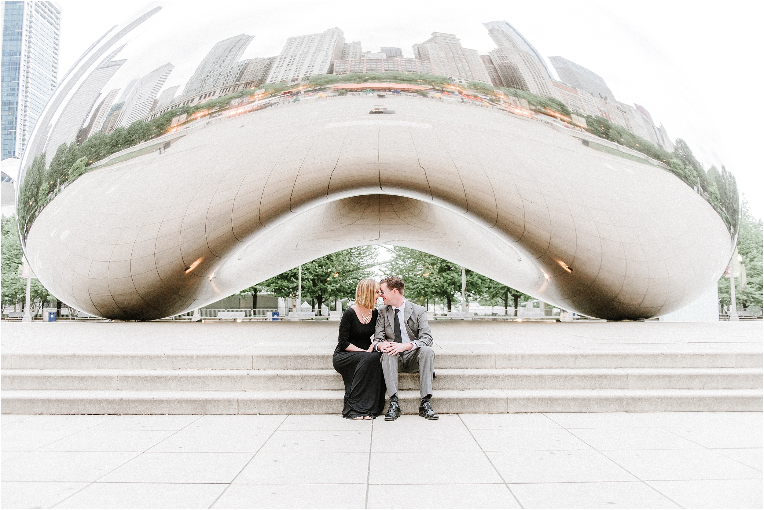 couple sitting in front of the bean in millennium park