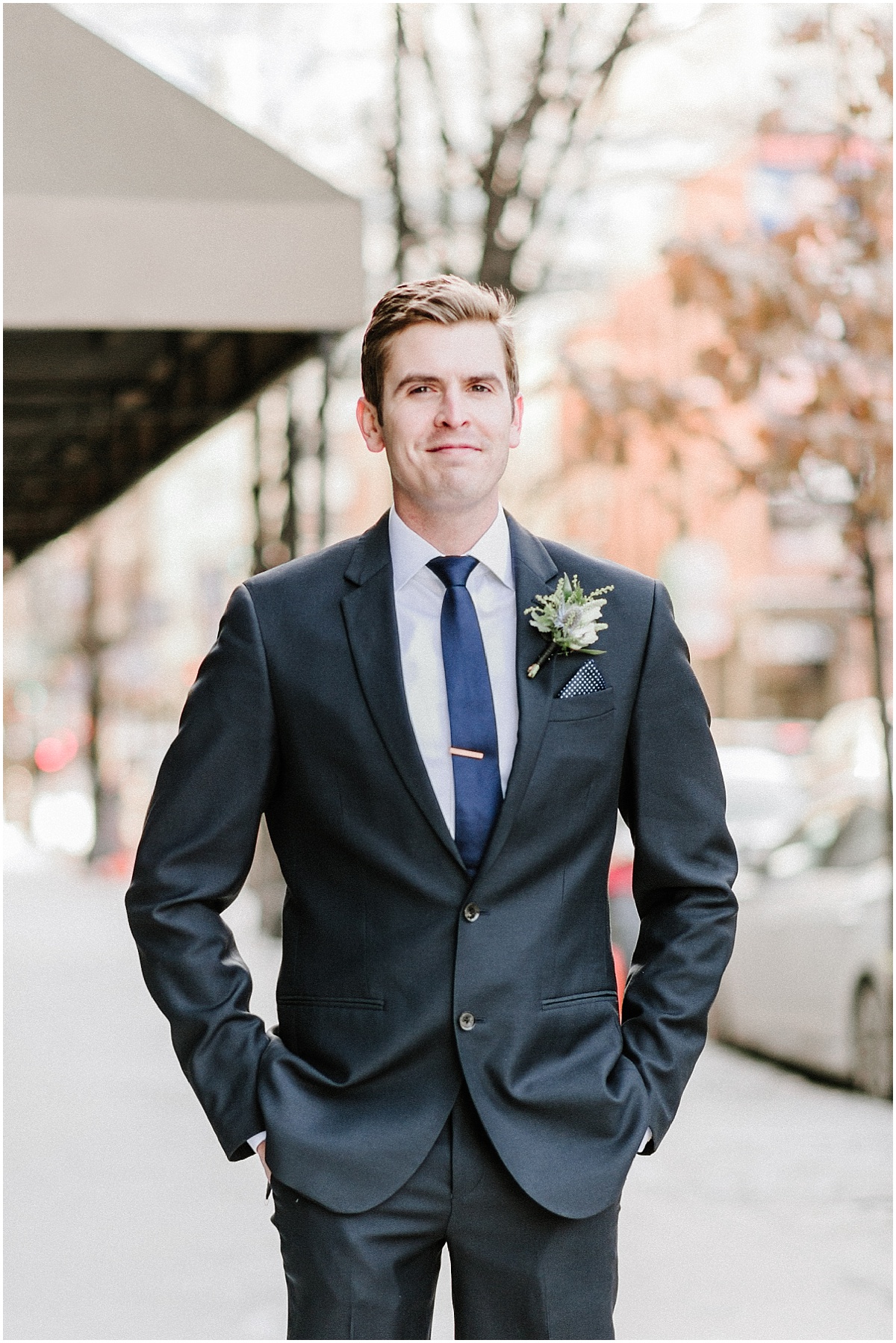 groom in blue suit and blue tie with hands in pockets in chicago