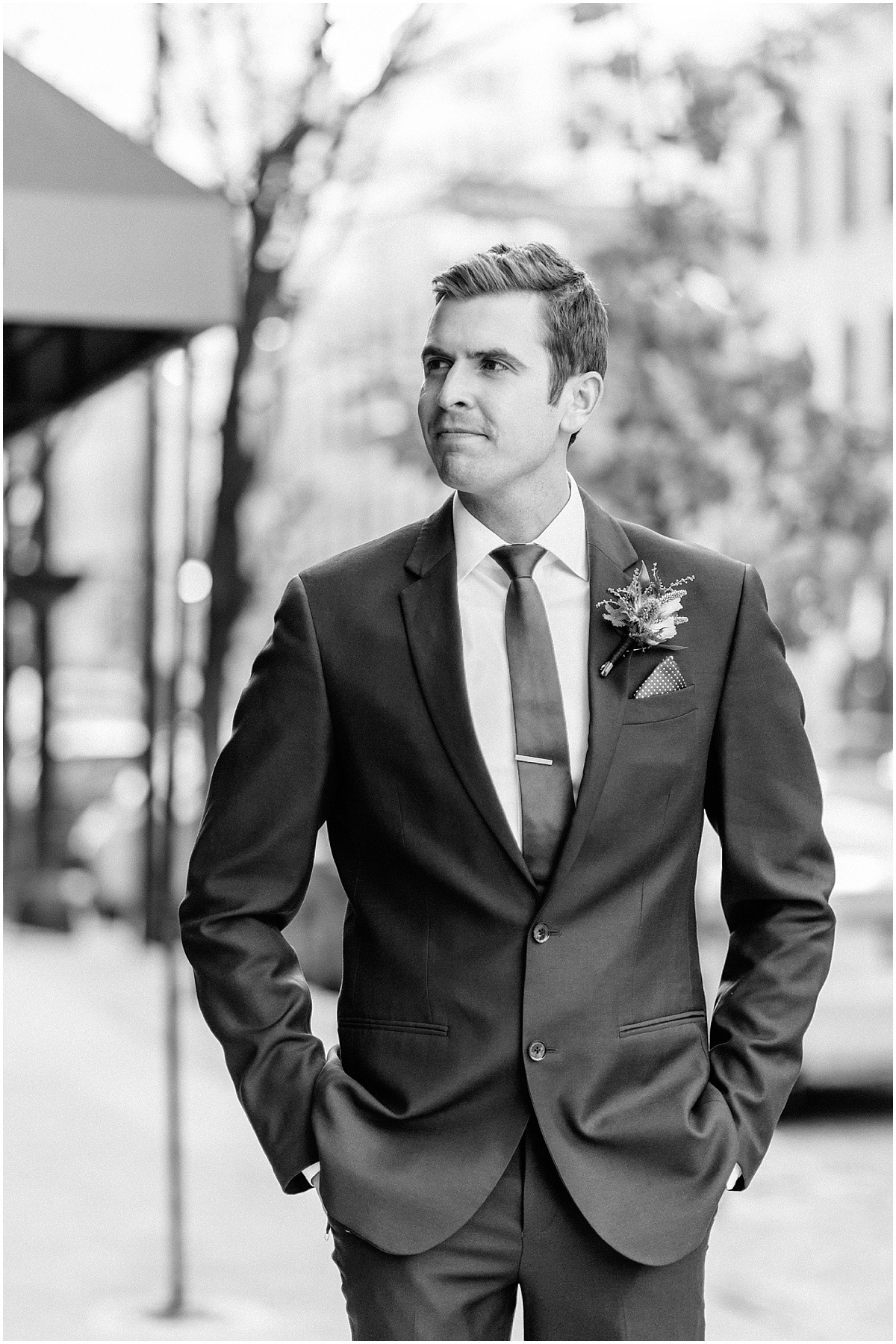 groom with hands in pockets looking away