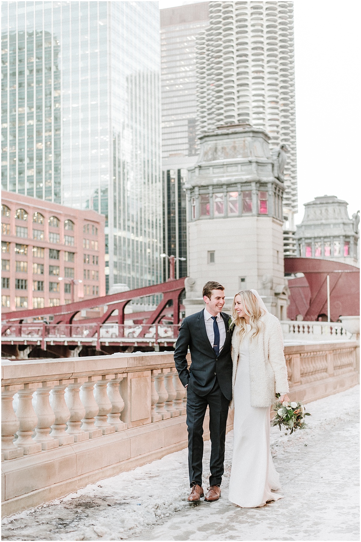 bride and groom walking along river in downtown chicago during winter wedding