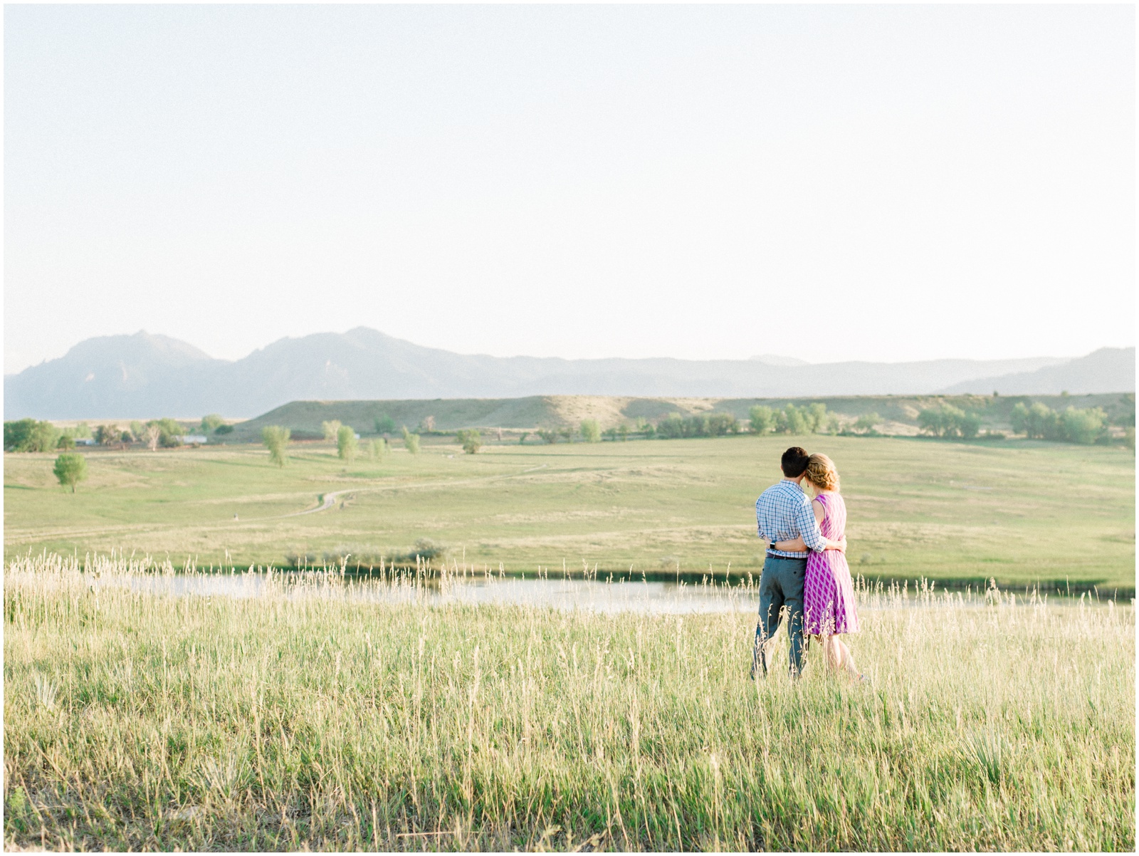 Couple in field with mountains | Boulder Valley Ranch engagement