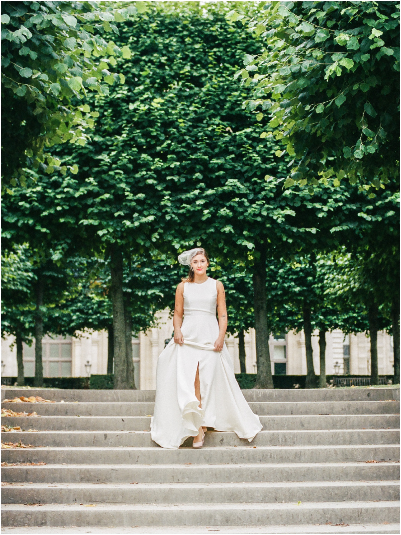 Bride walking down stairs at Louvre in silk dress with slit