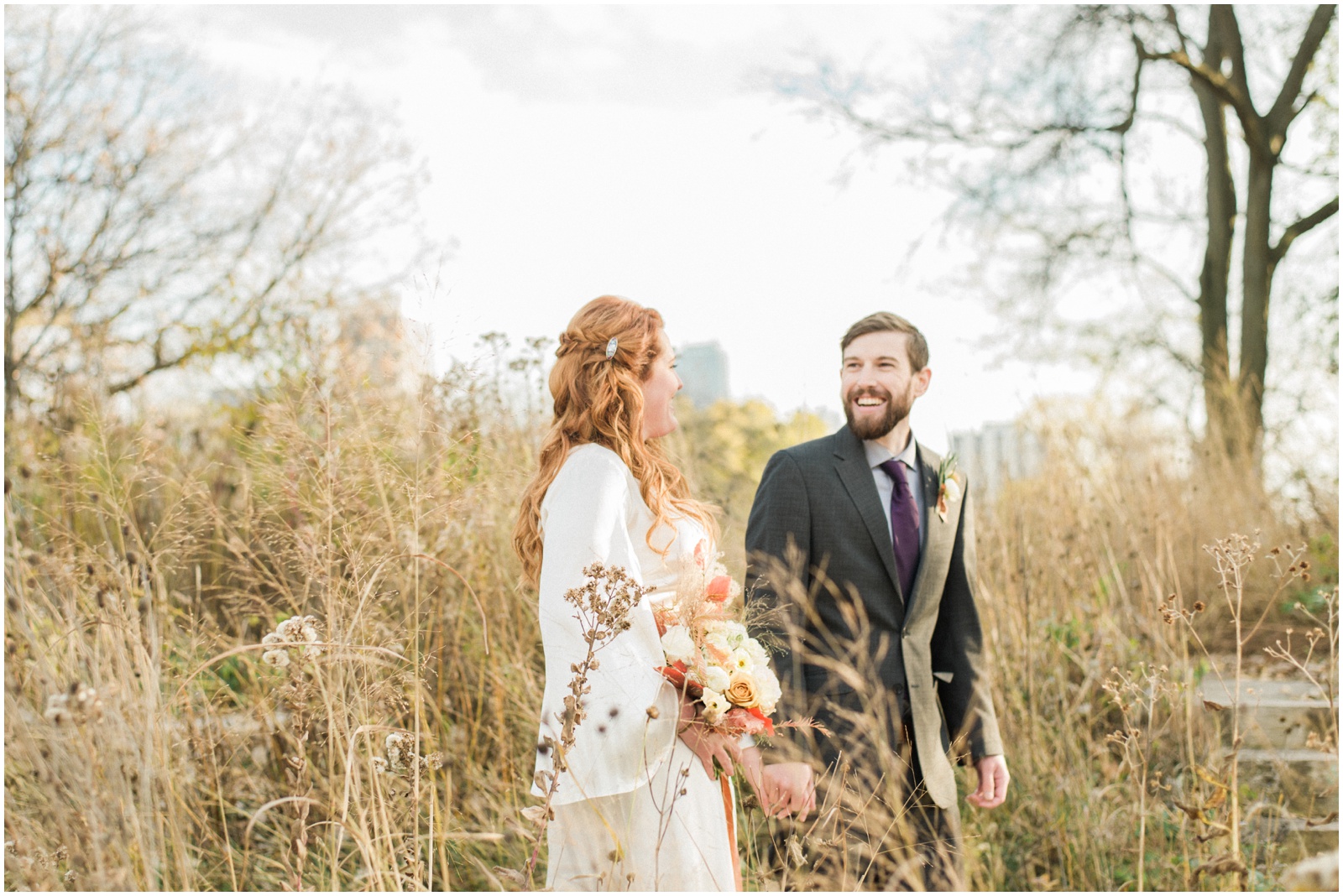 bride and groom walking behind tall grass
