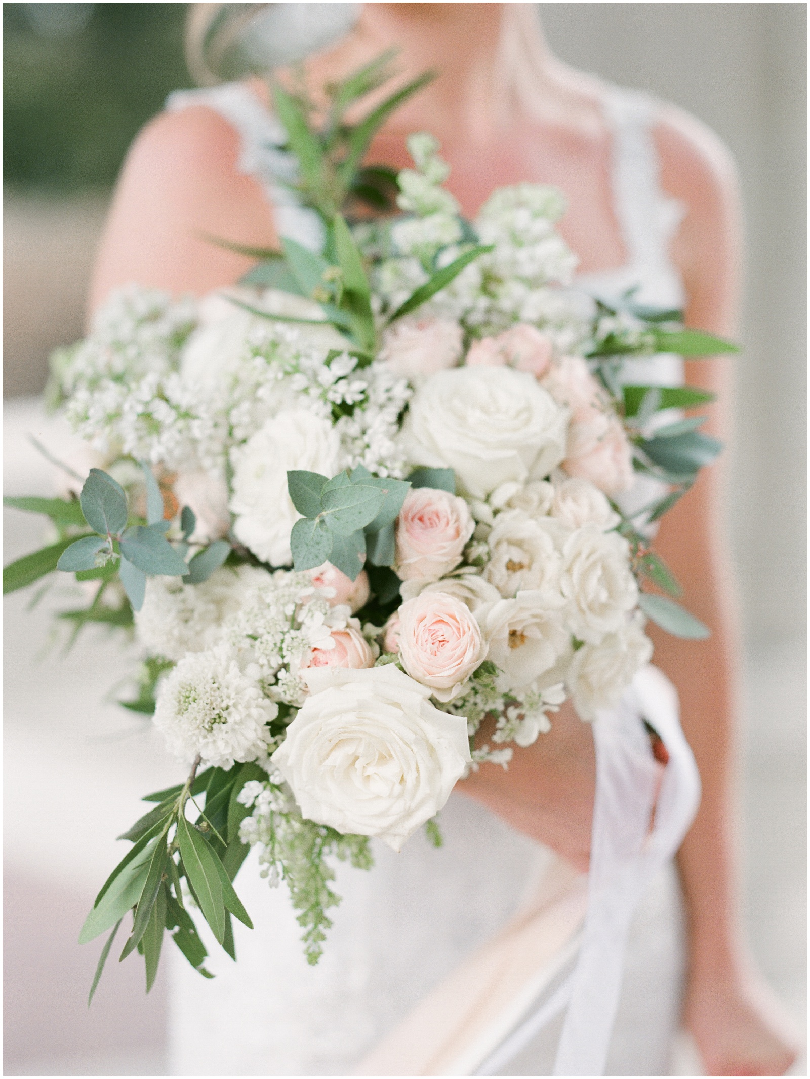 bride holding blush and white wedding bouquet