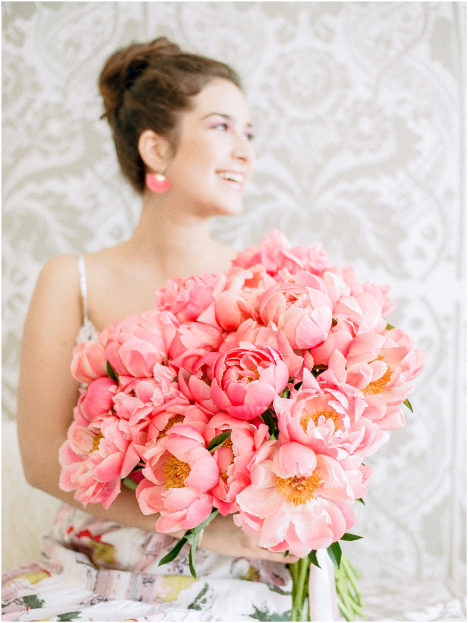 girl holding giant bouquet of pink coral peonies