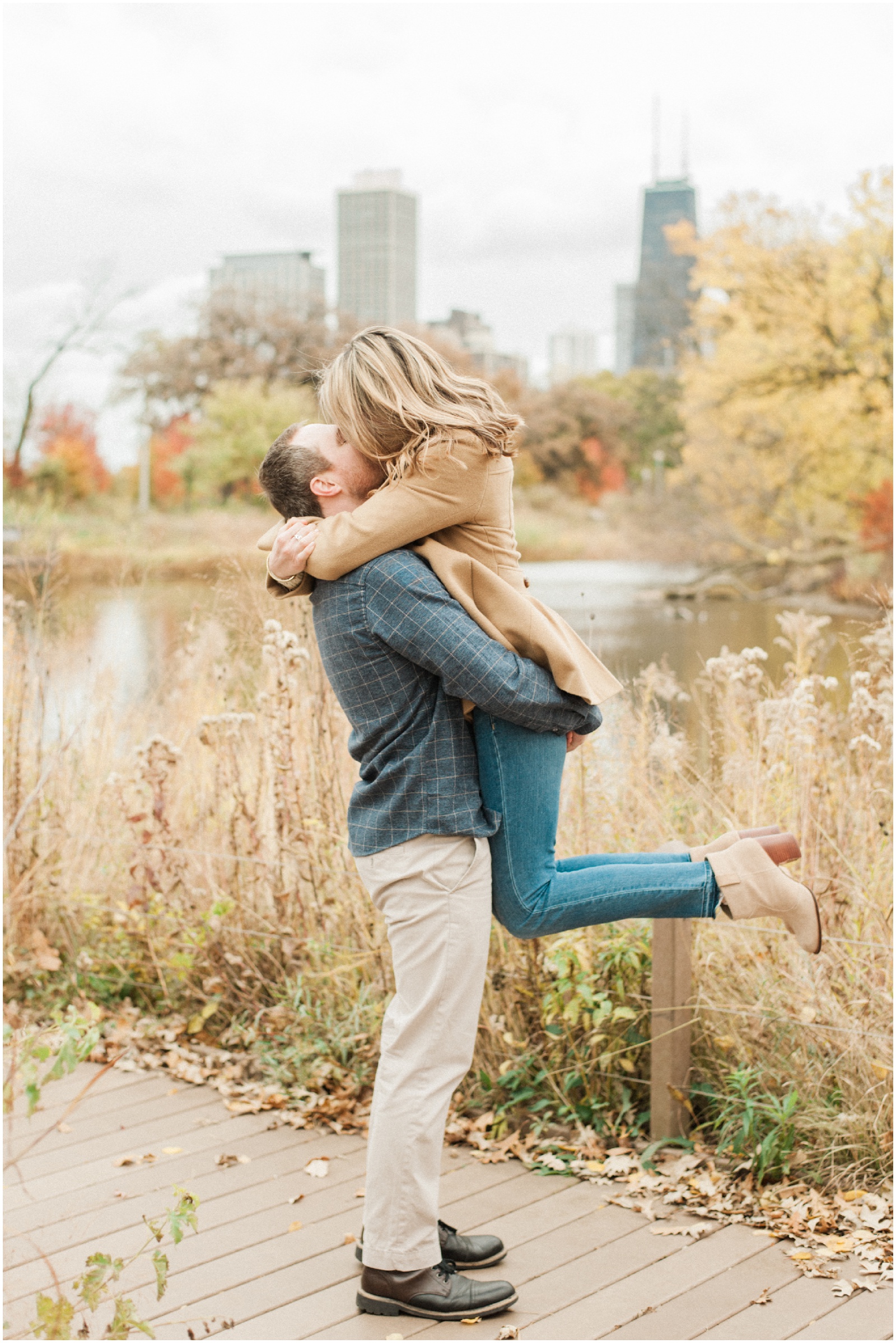 guy lifting girl off the ground and kissing during engagement photos in lincoln park chicago