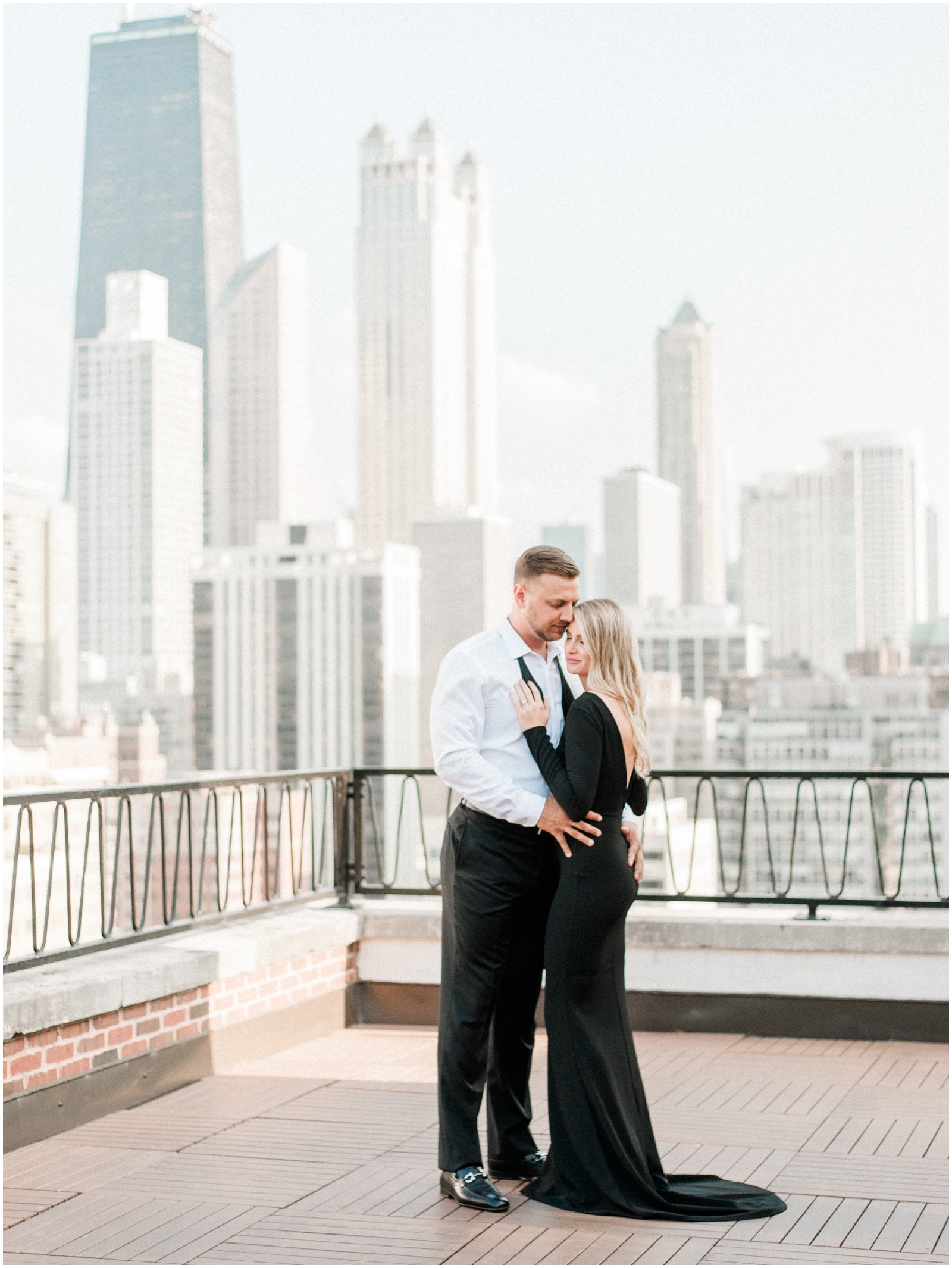 couple hugging on rooftop overlooking chicago skyline for engagement