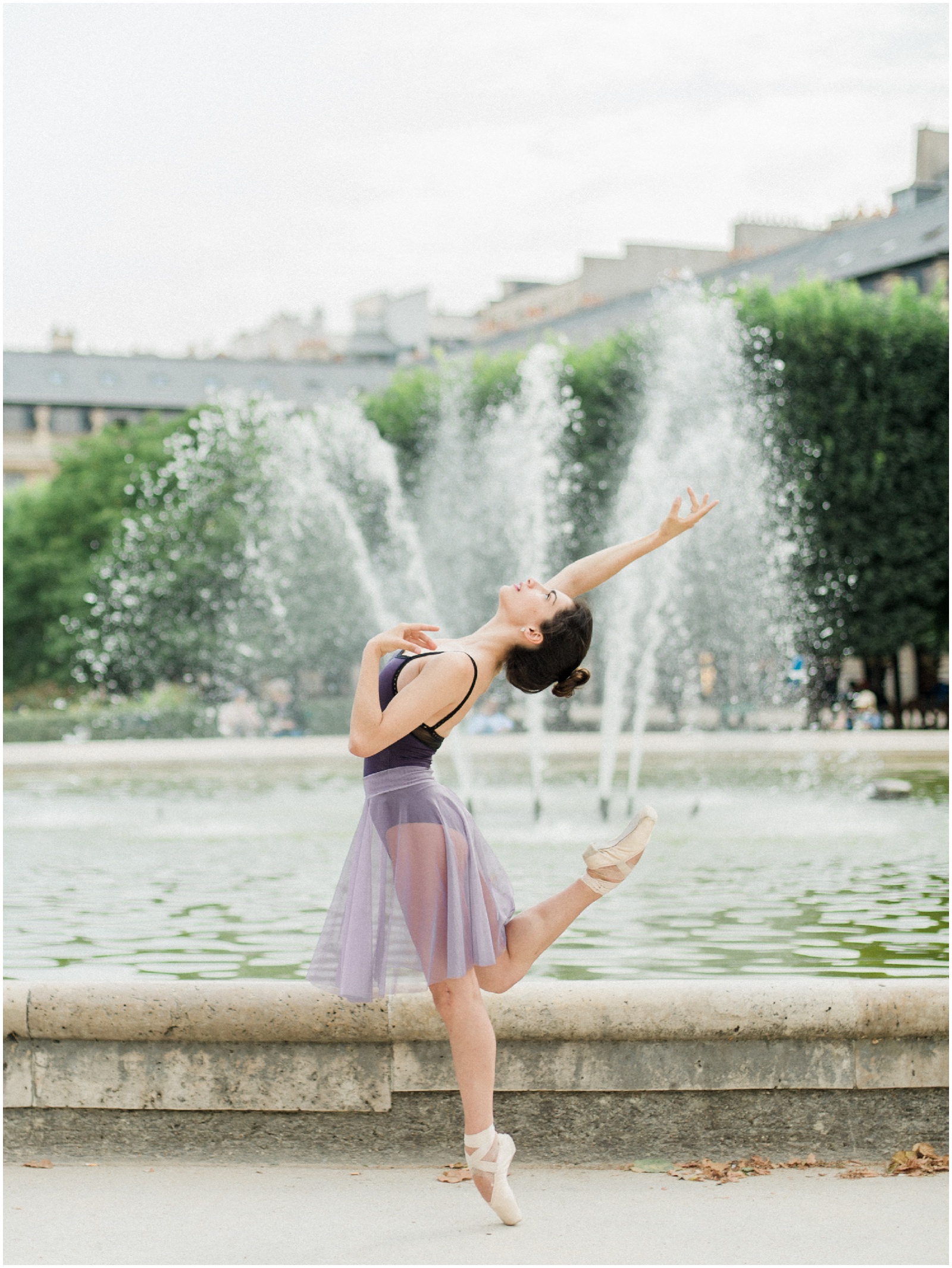 paris ballerina wearing purple tutu in front of a fountain
