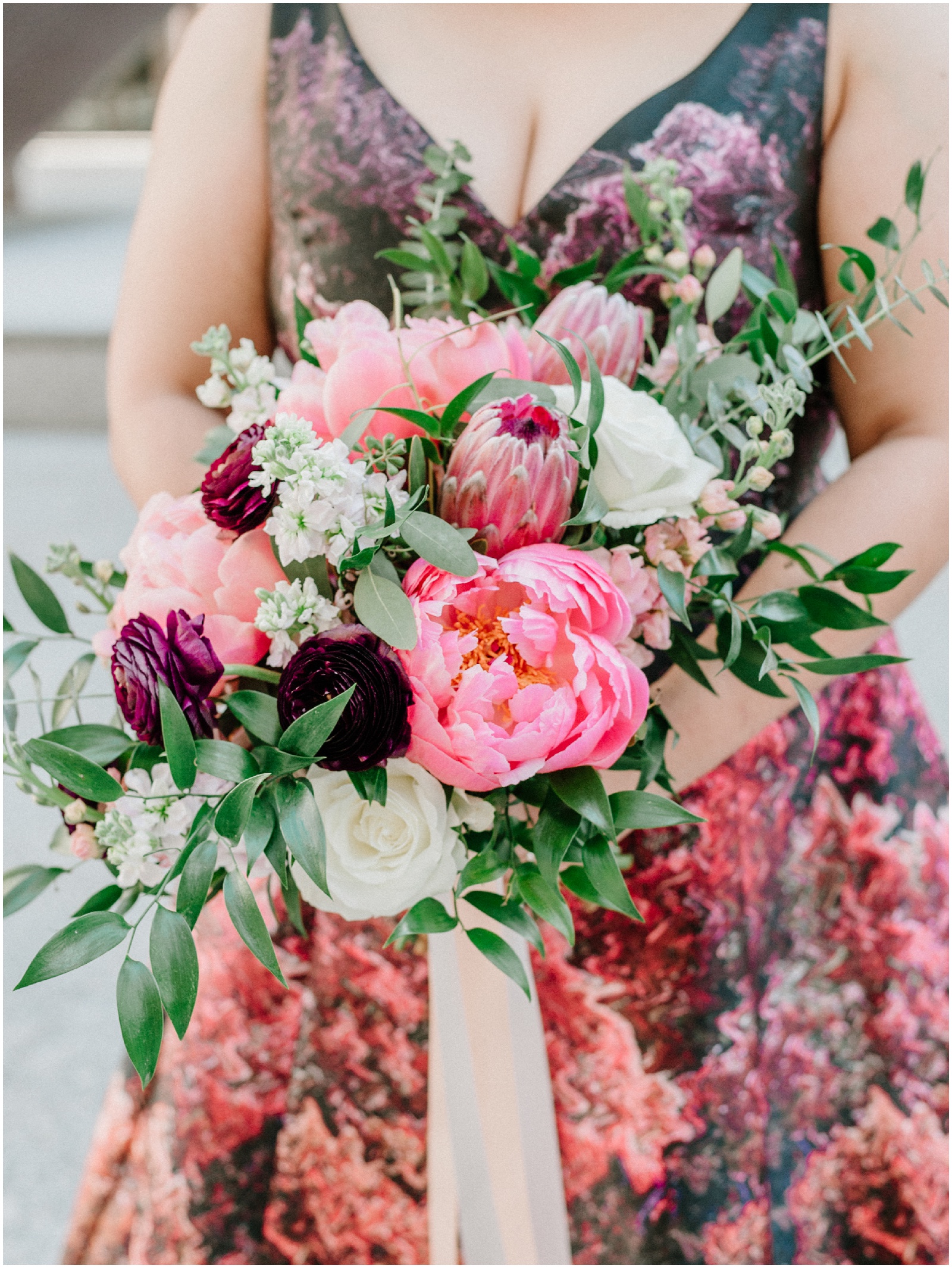 bride holding pink purple wedding bouquet with peonies and proteas