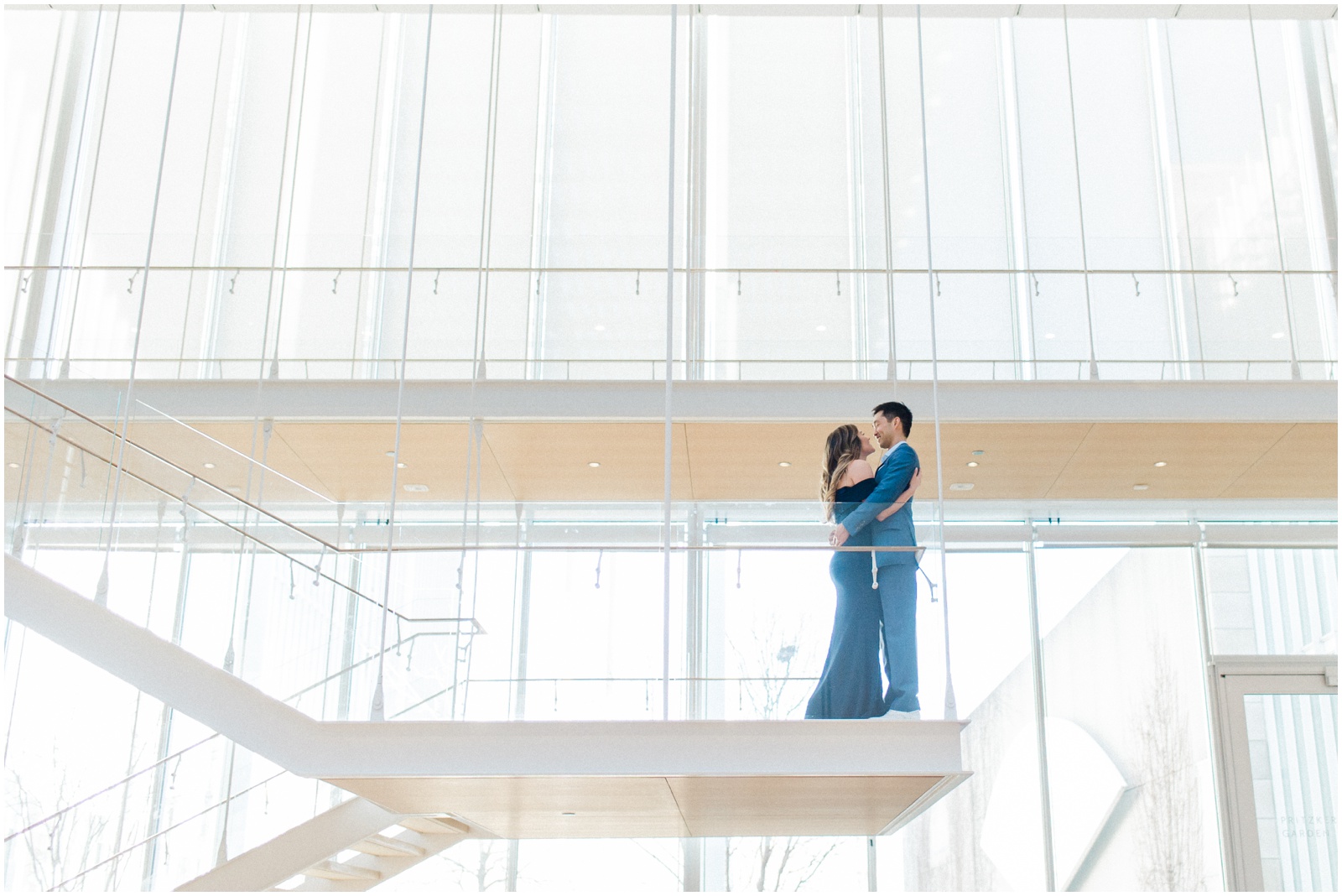 couple standing on glass staircase with windows
