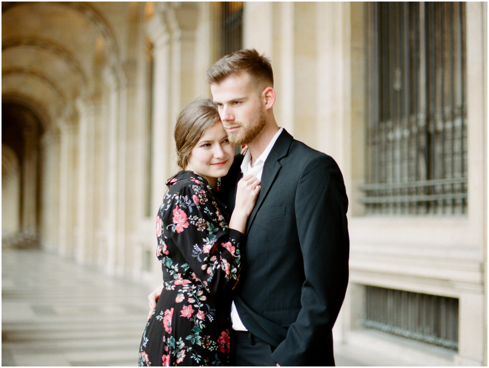 couple wearing elegant black outfits at Louvre Museum for photo shoot