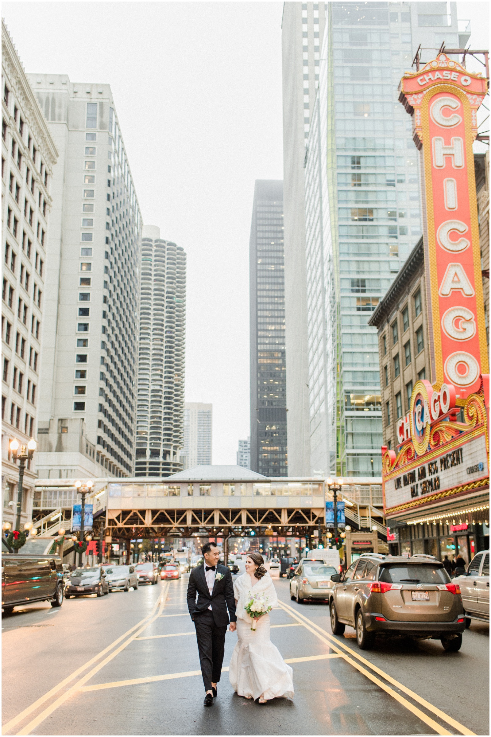 bride and groom walking in downtown chicago by chicago theatre