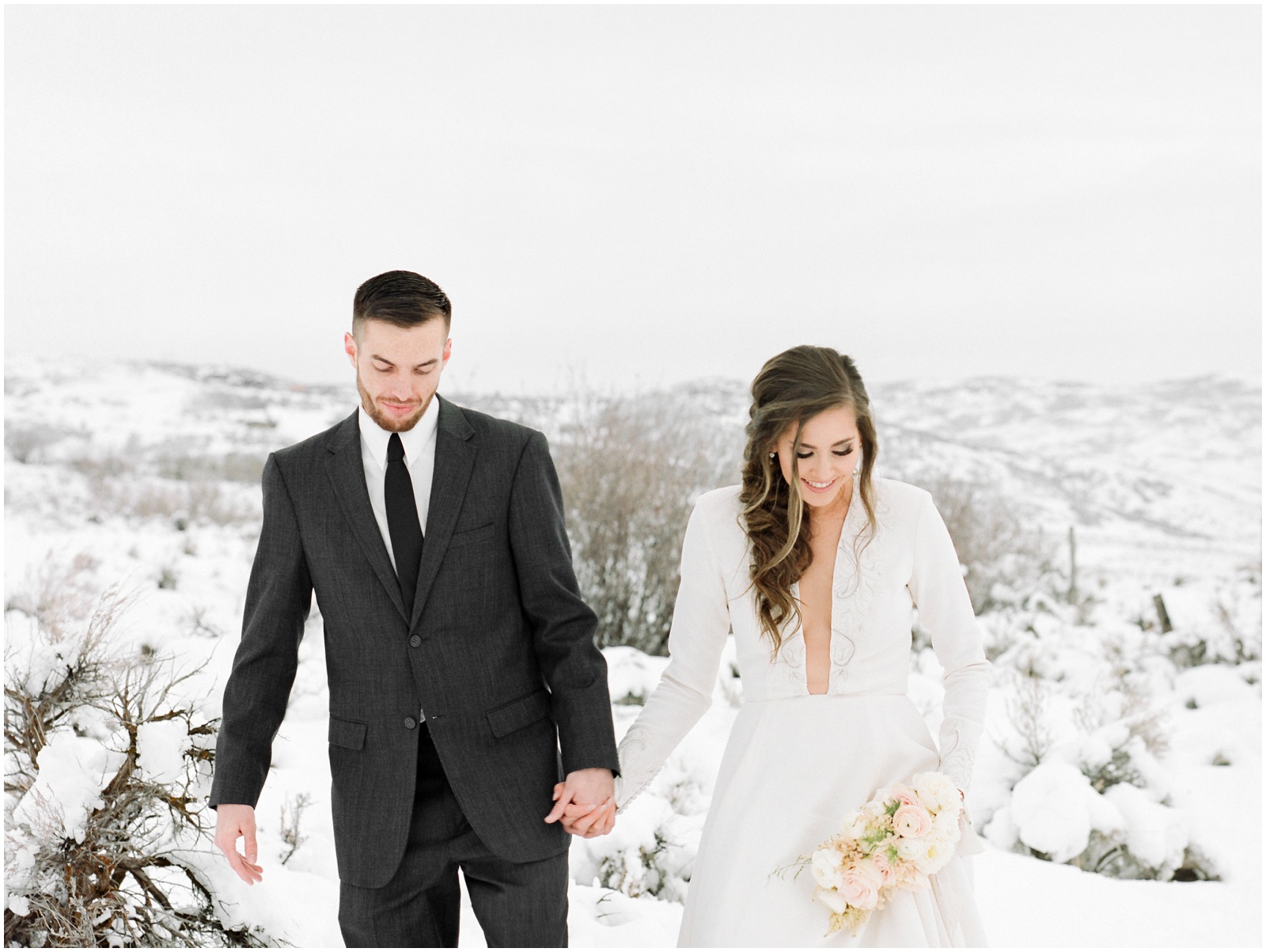 bride and groom walking through snow during elopement