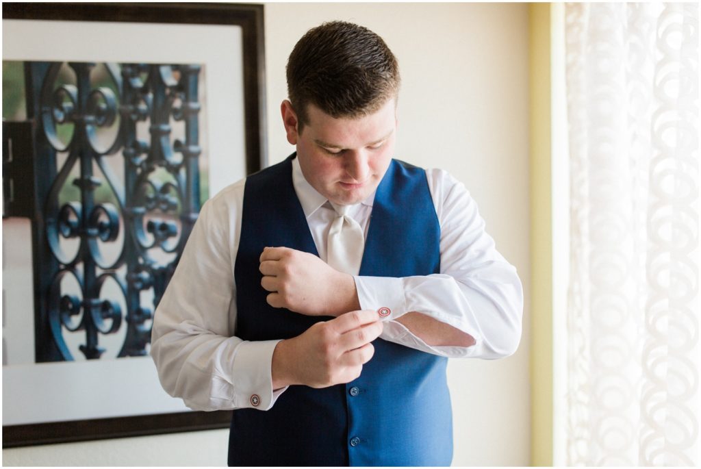 groom putting on cufflinks