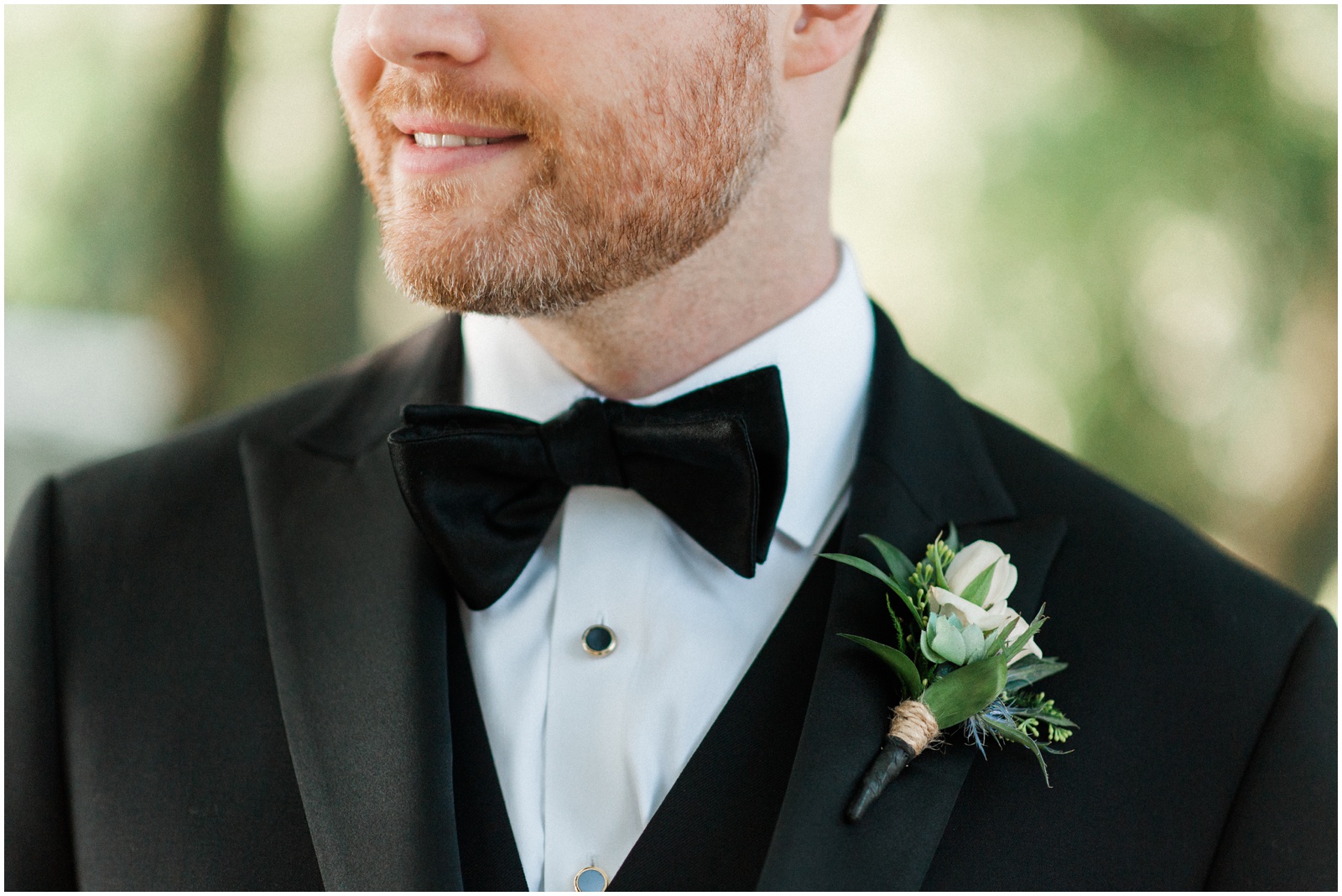groom in black tux with white boutonniere 