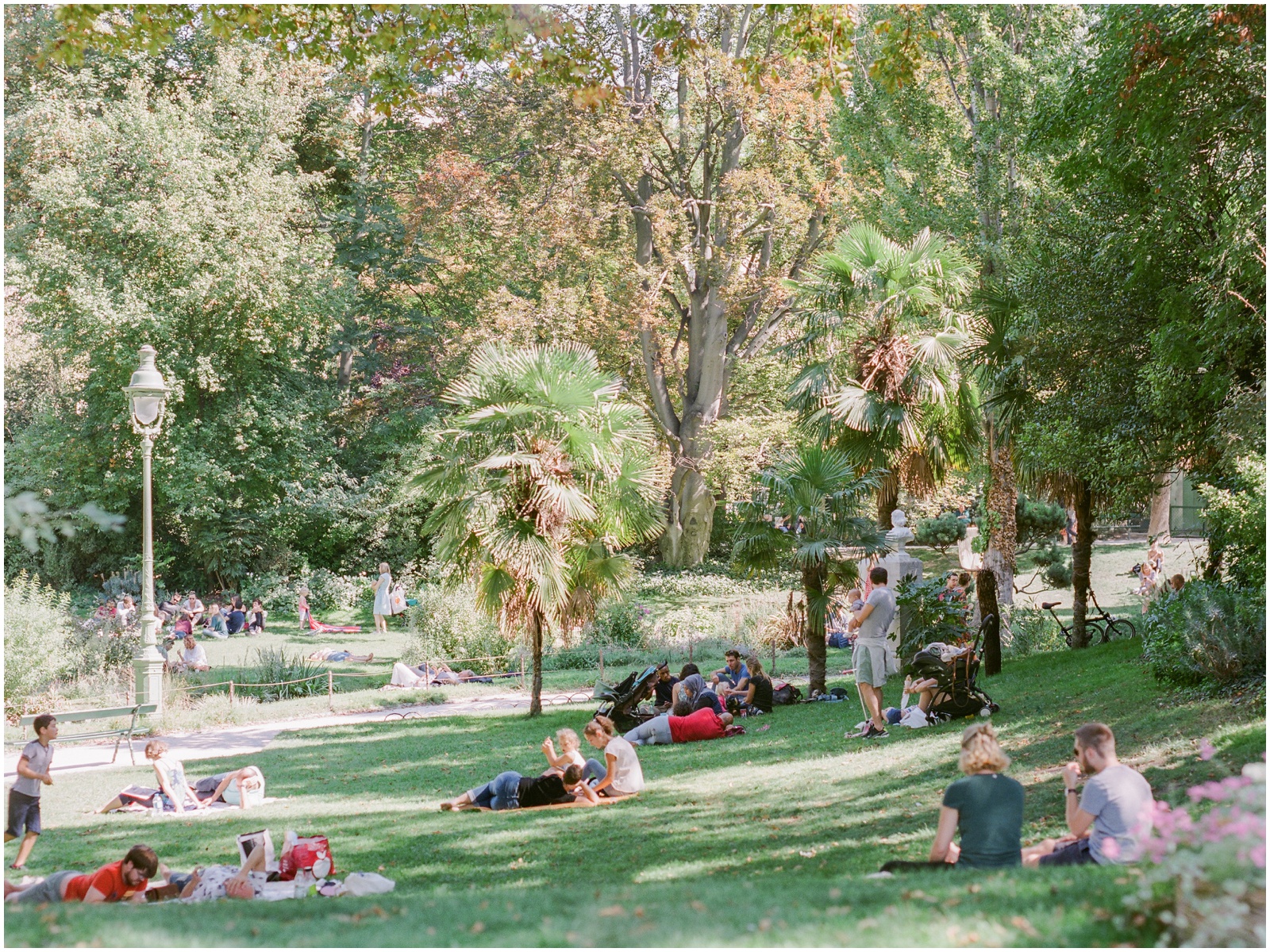 people relaxing in square des batignolles in paris