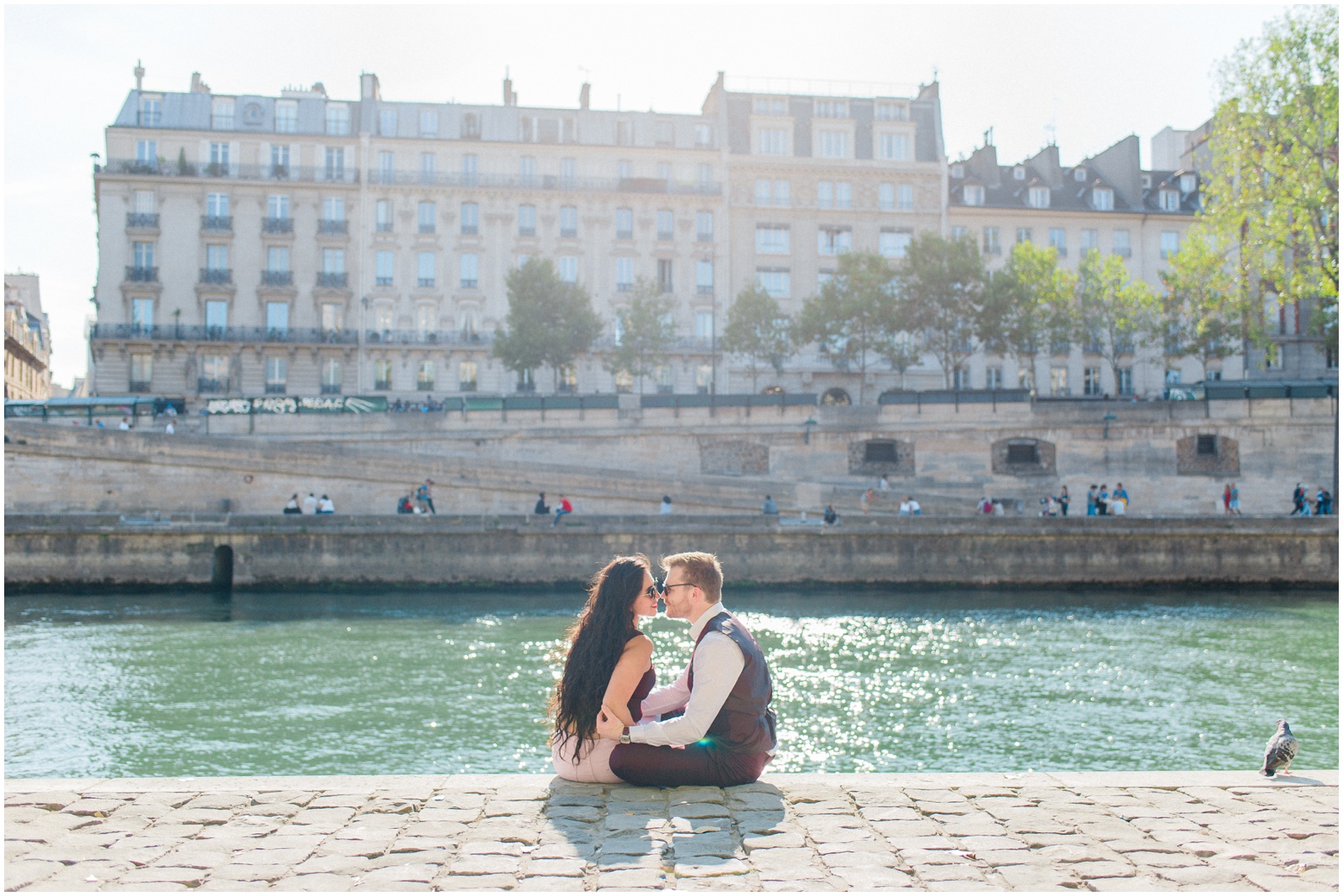 couple sitting along the seine river