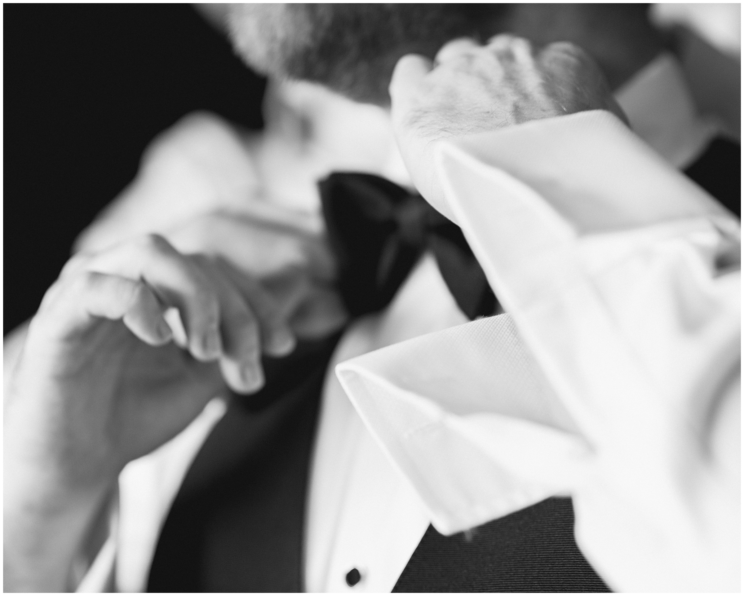 groom putting on bowtie